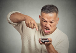Angry man points at his cell phone