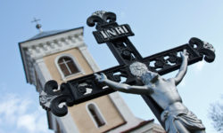 A crucifix stands in front of a church.