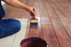 man painting wood floor