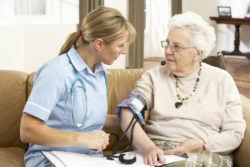 Senior woman has blood pressure taken by a nurse.