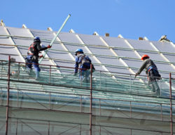 construction workers on roof regarding Edmonton leaky police building lawsuit