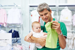 Dad shopping for infant clothes with his baby
