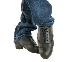 Close up of male Irish dancer feet in black shoes and blue jeans