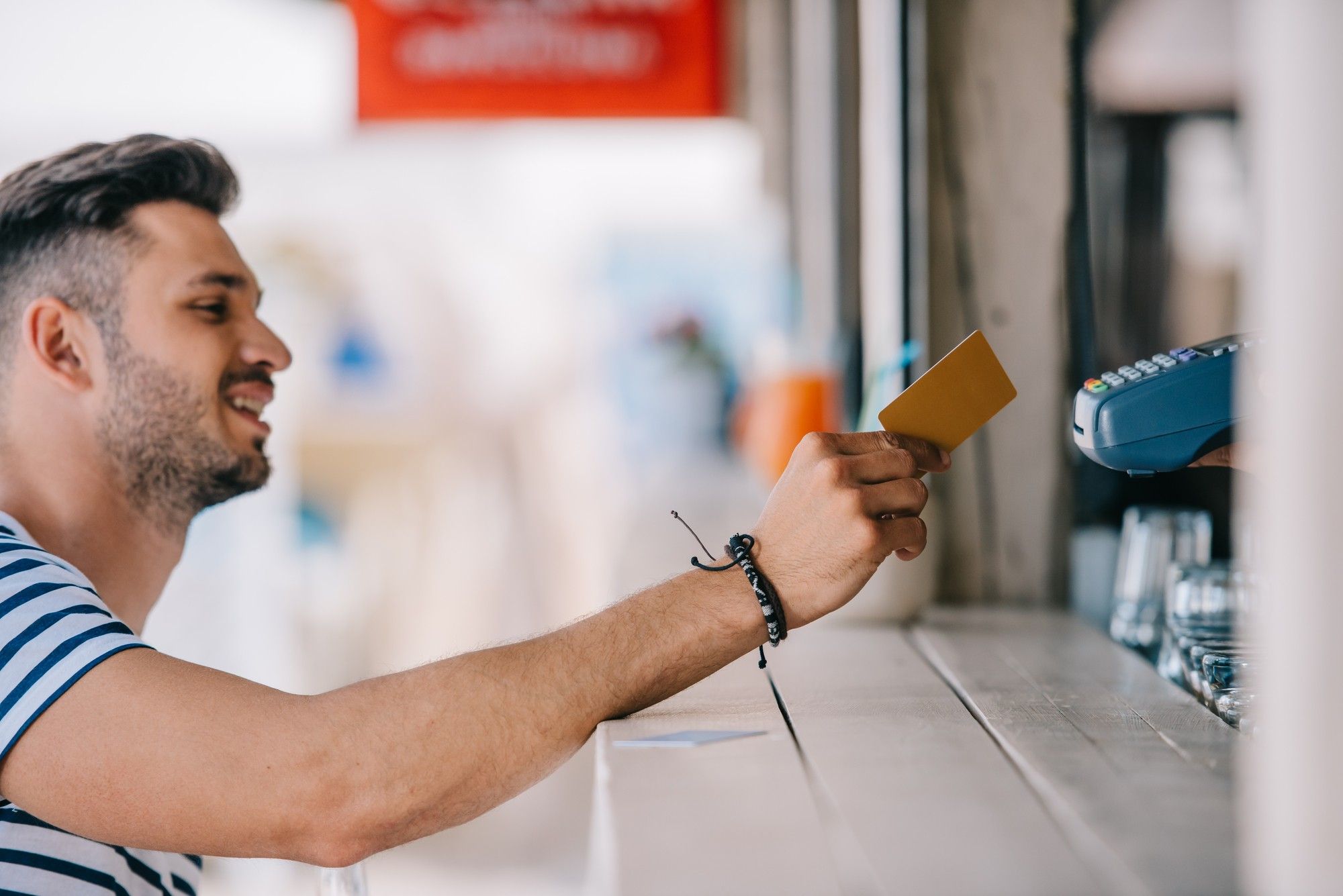 man-at-walk-up-window-paying-with-credit-card