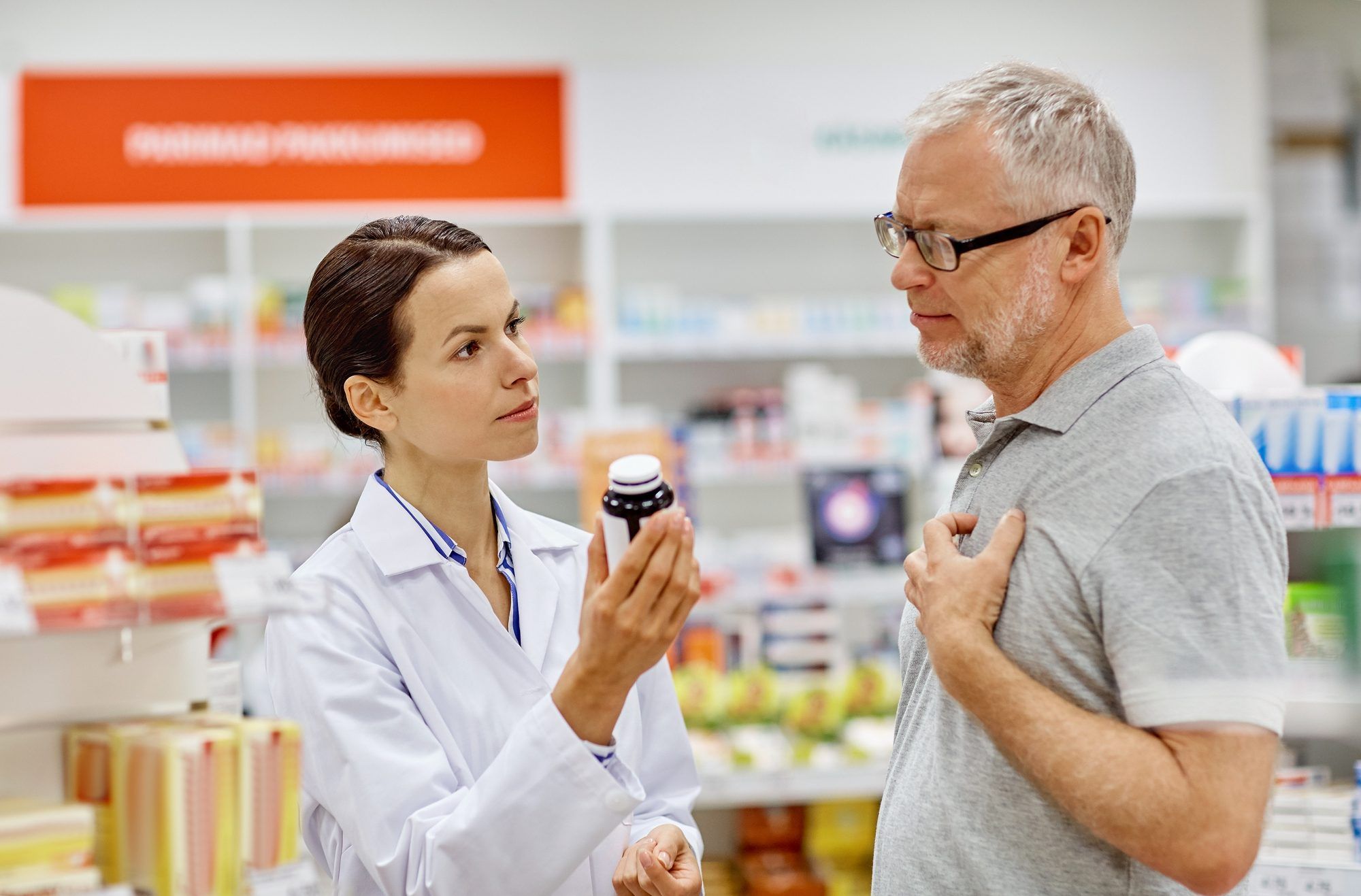pharmacist helping male patient with medication