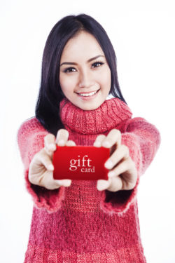 Happy woman showing gift card