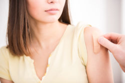 Woman getting bandaid after vaccine