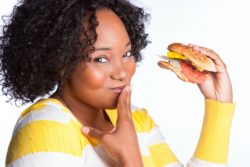 Woman eats a cheeseburger