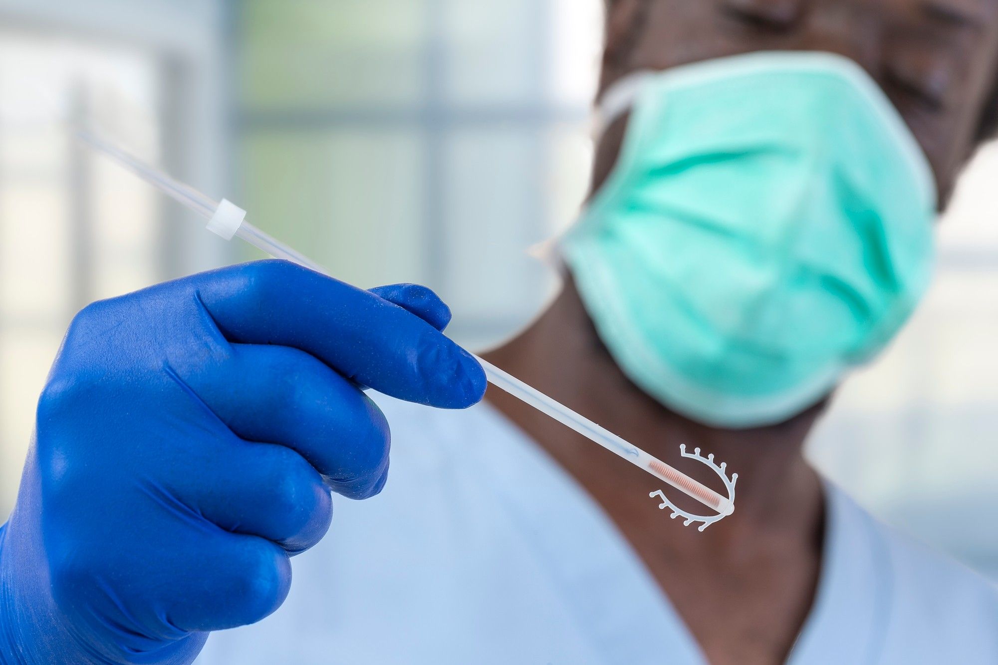 african american doctor preparing to insert IUD