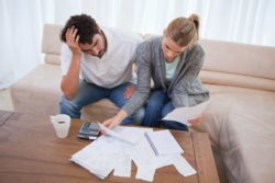 stressed couple looking at bank statements