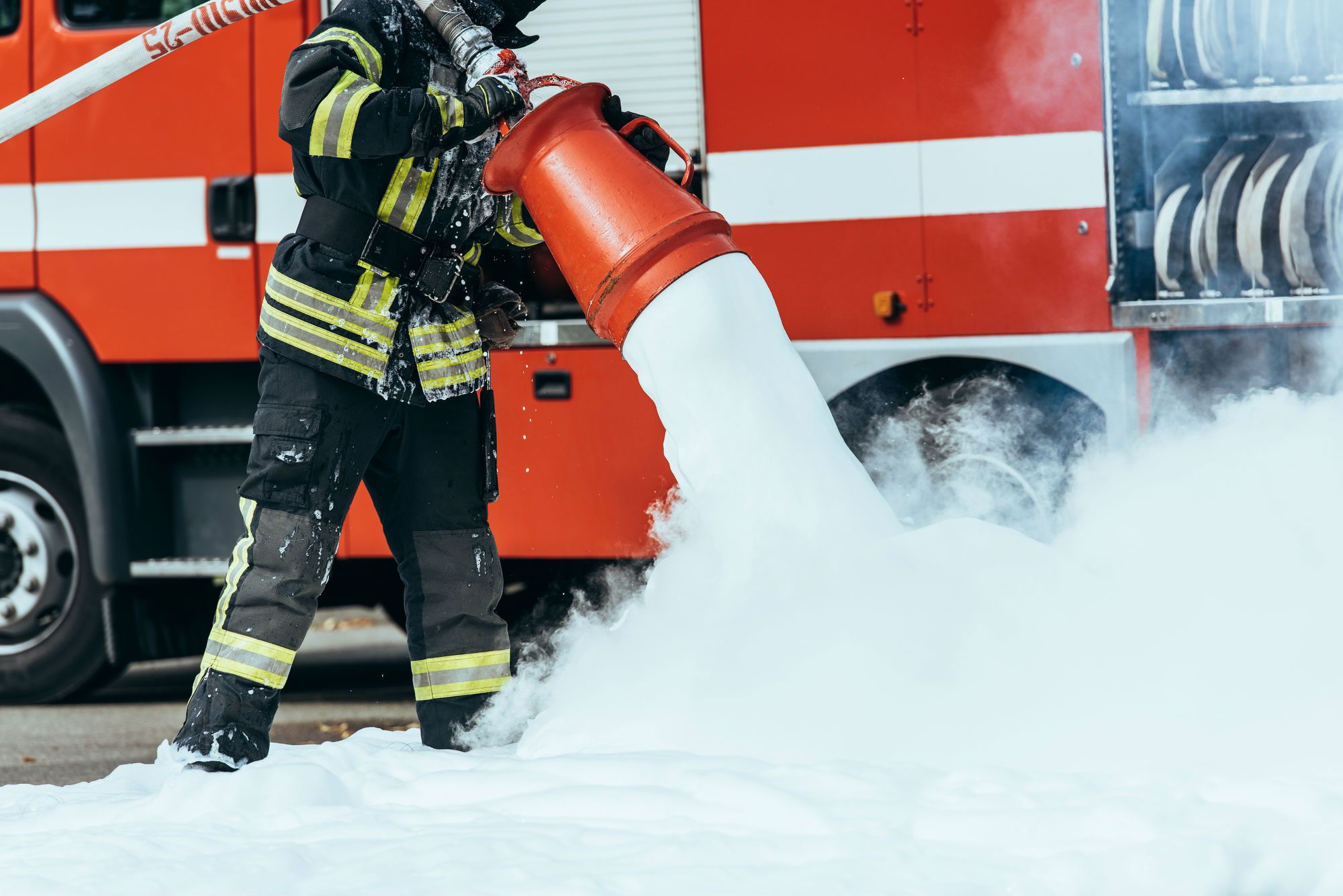 Firefighter uses firefighting chemical foam on street