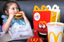 little girl eating McDonald's Happy Meal regarding proposed class action settlement