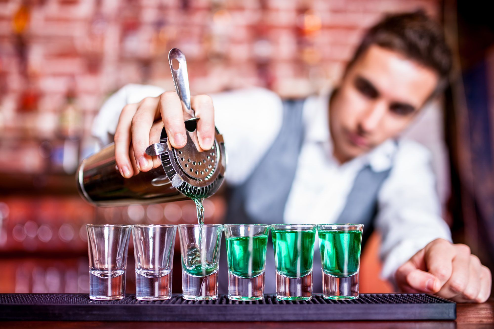 male bartender pouring drinks at bar