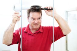 man blow drying his hair
