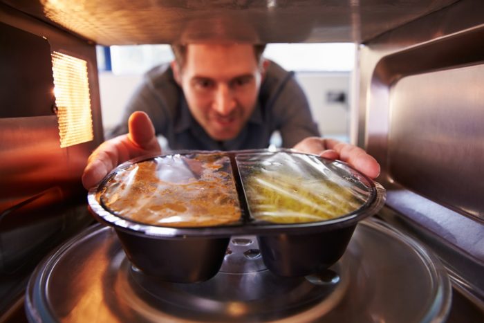 man placing food into a bosch microwave