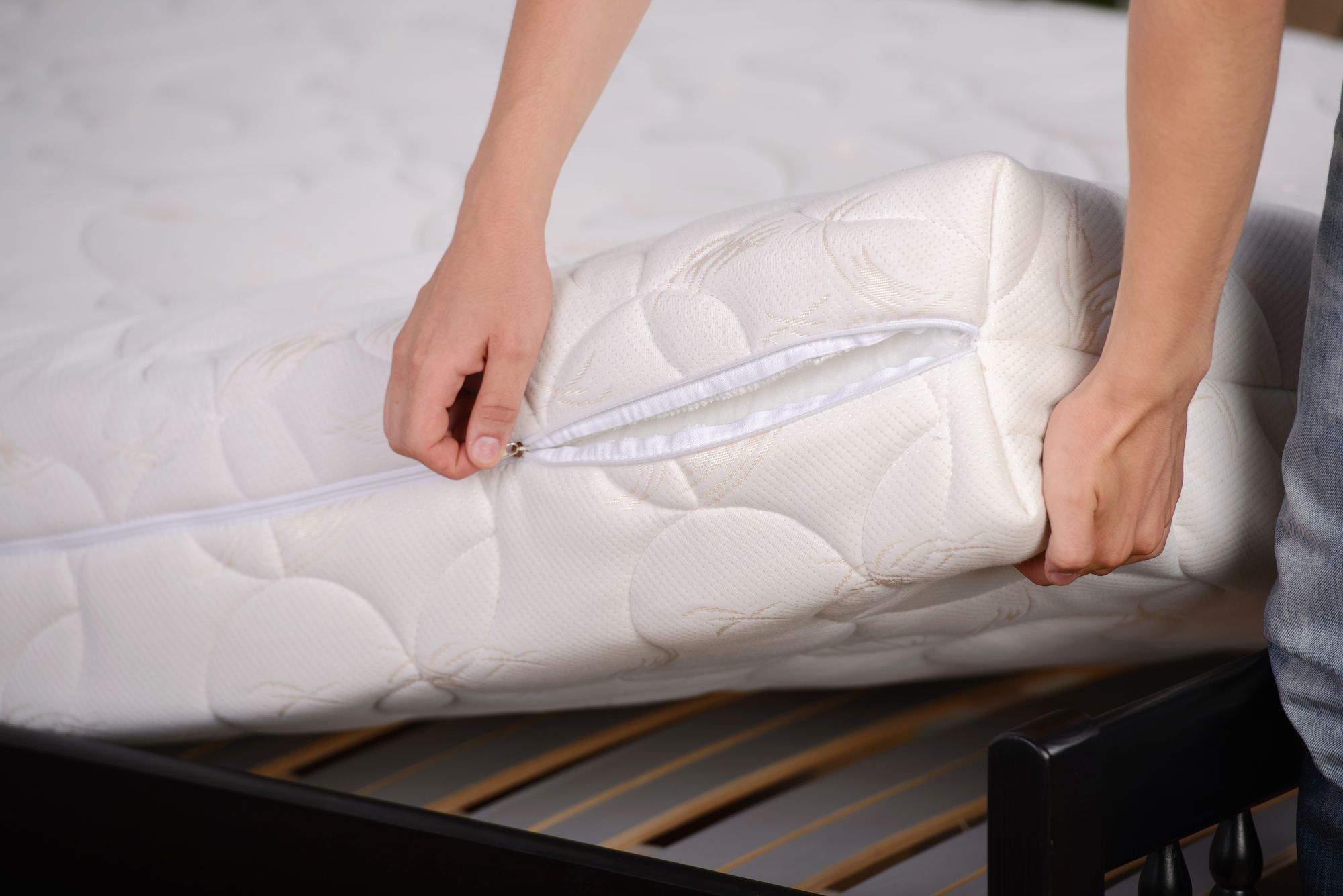 person removing mattress cover