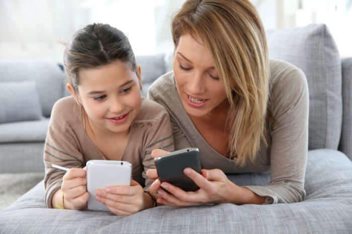 mom and child playing words with friends on their smartphones