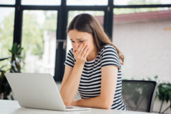 Woman looking at computer scared
