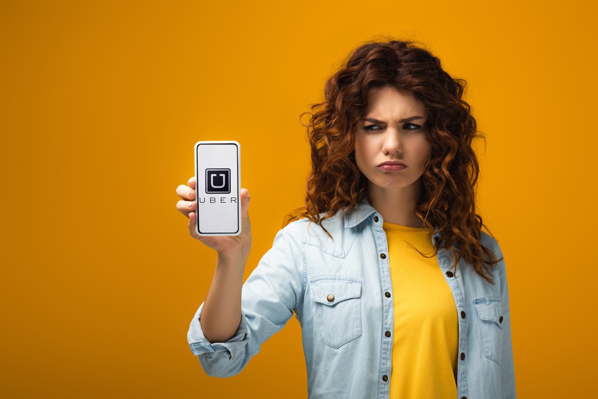 Girl holding Uber app on phone and looking man