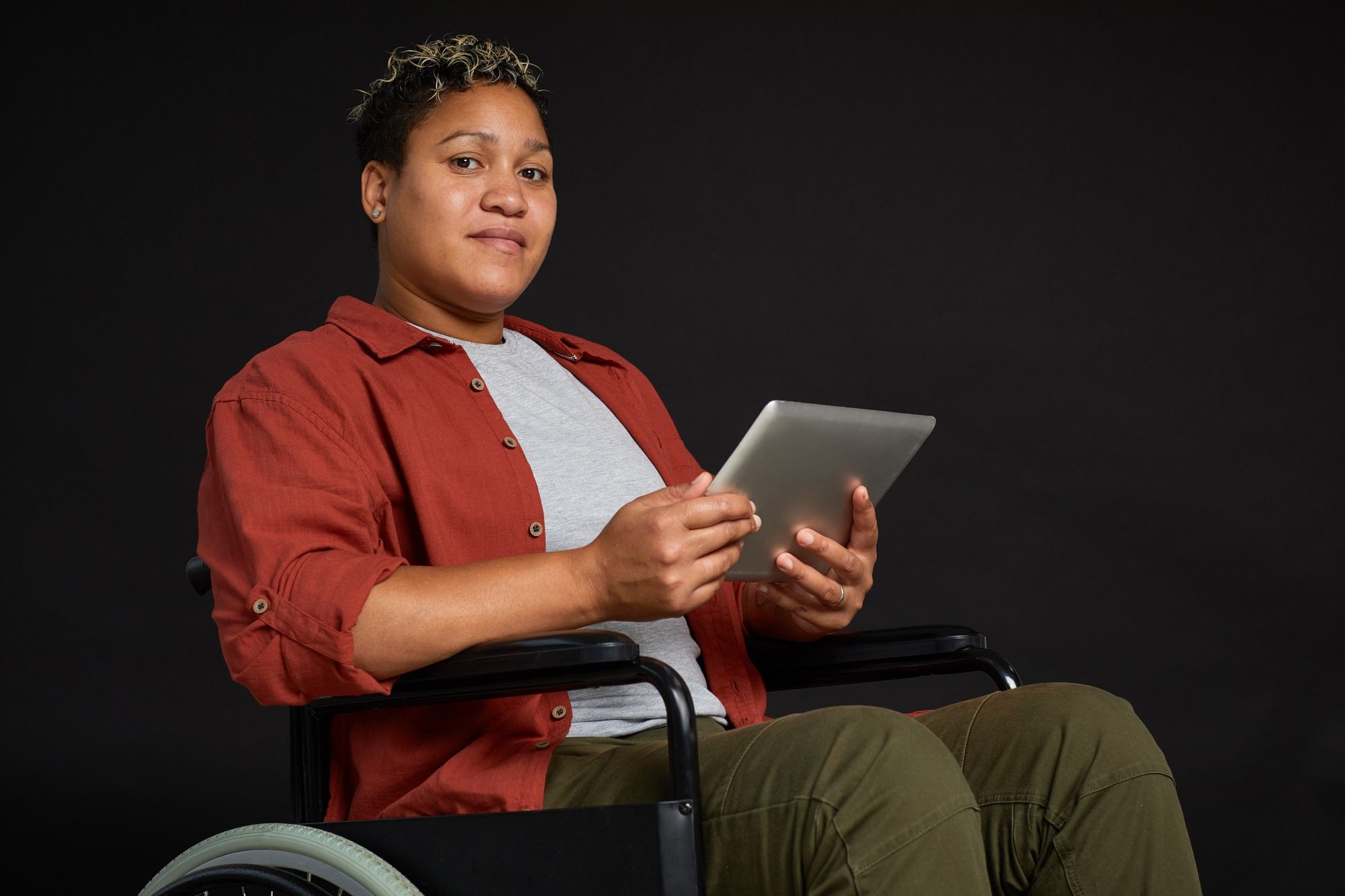 Disabled woman in wheelchair holds electronic tablet