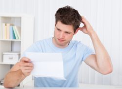 Confused man holding paper from HP printer