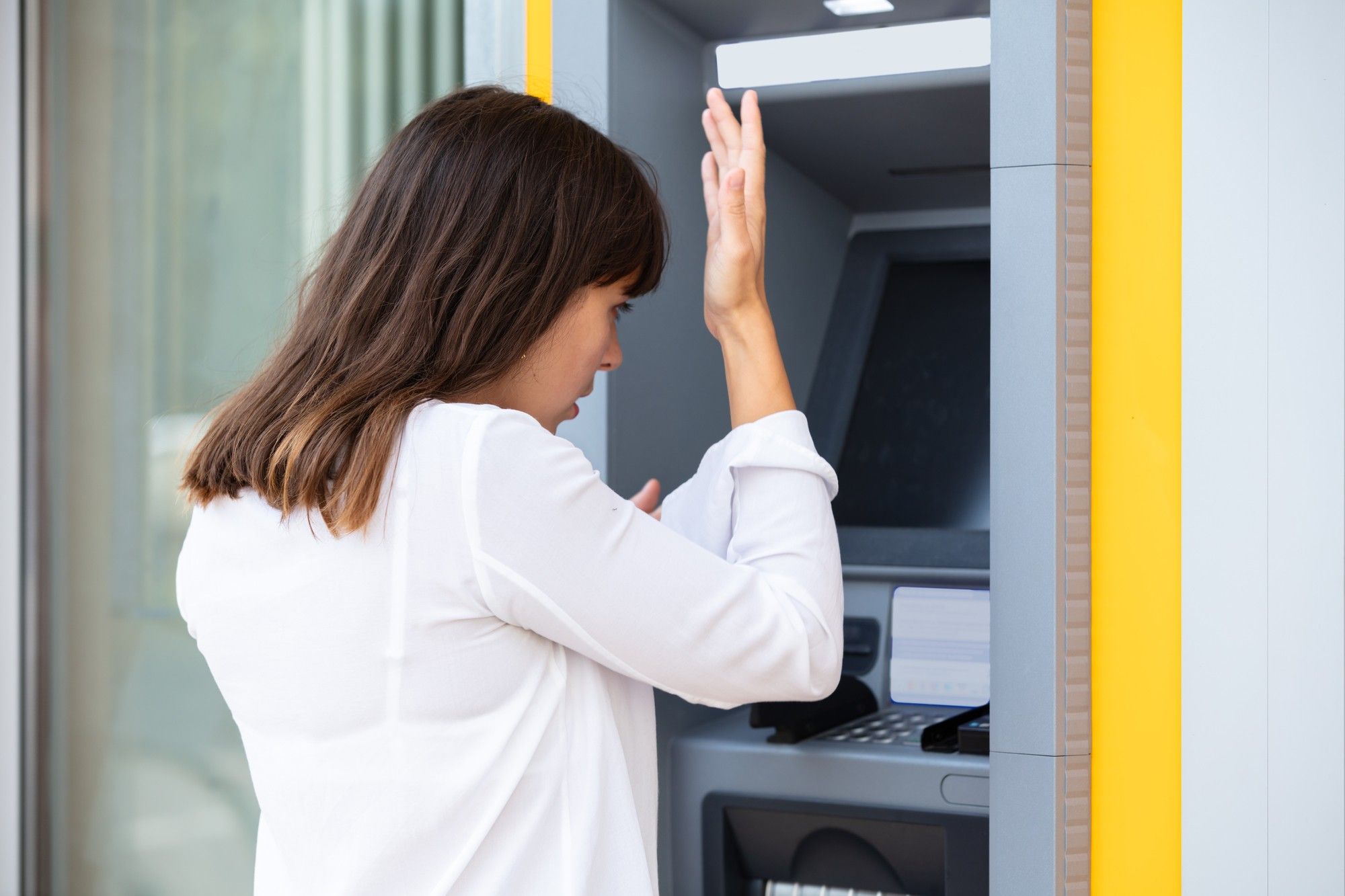 angry stressed woman at credit union ATM machine