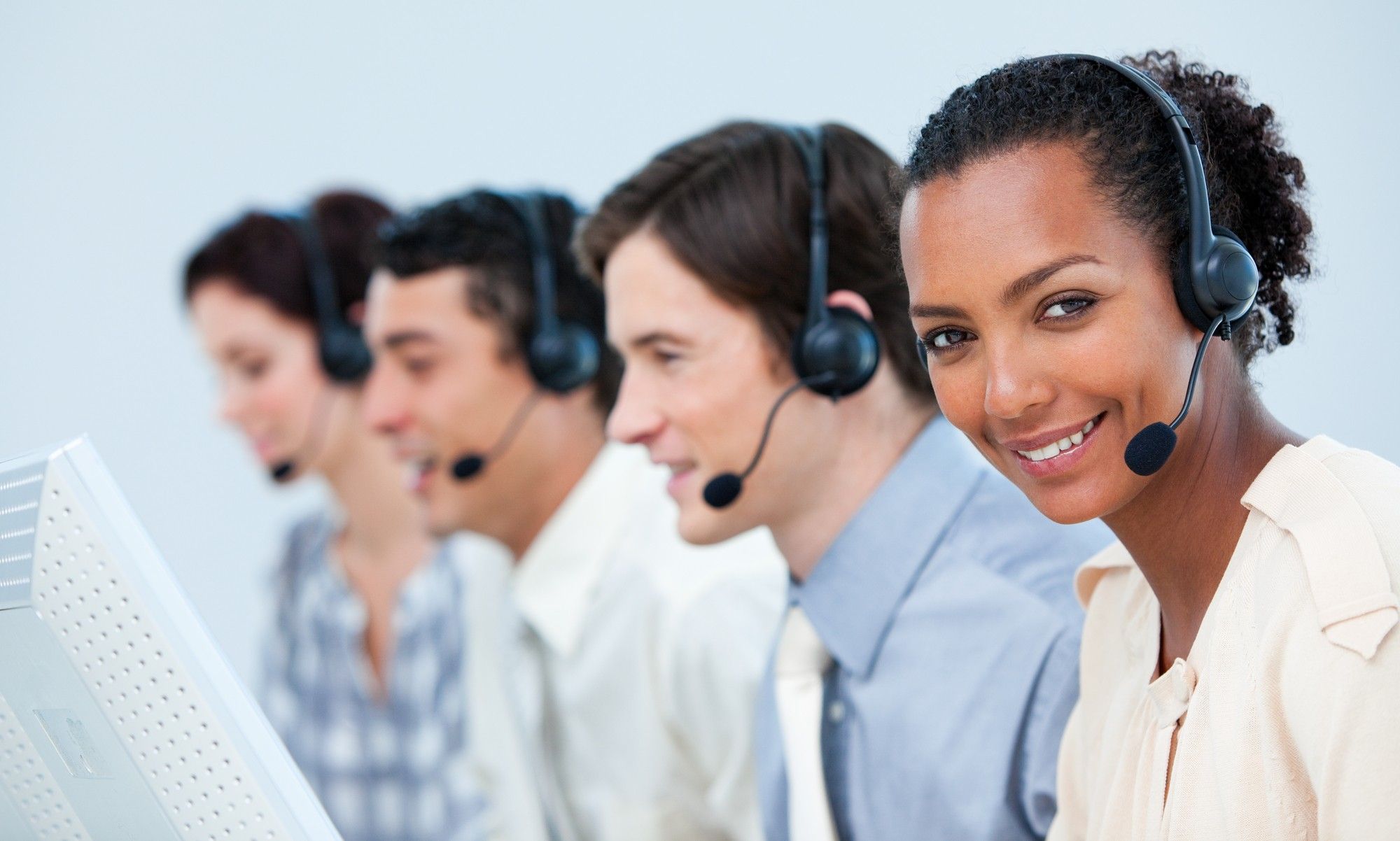 Row of telemarketers wearing headsets