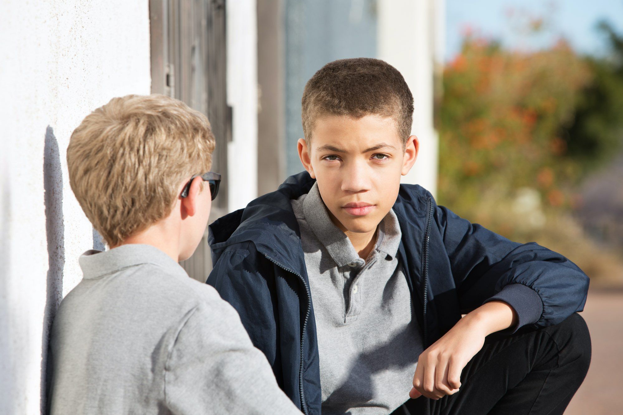 Two teen boys talking seriously outside