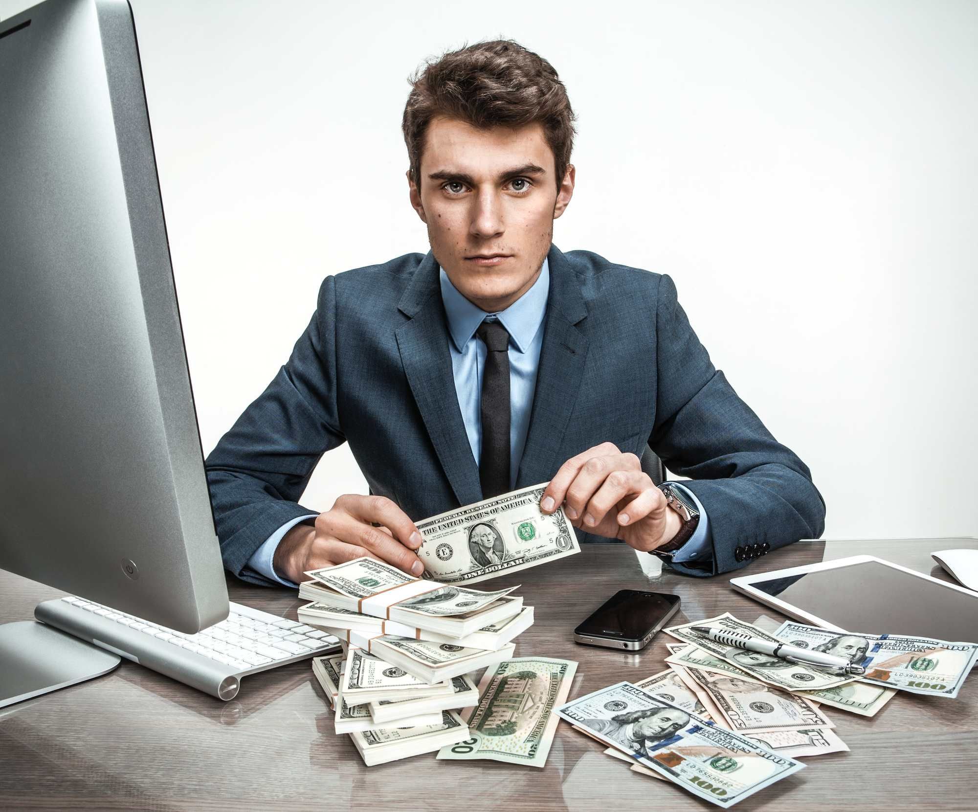 bank employee with lots of money on desk