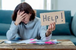 Woman holding help sign needing payroll relief