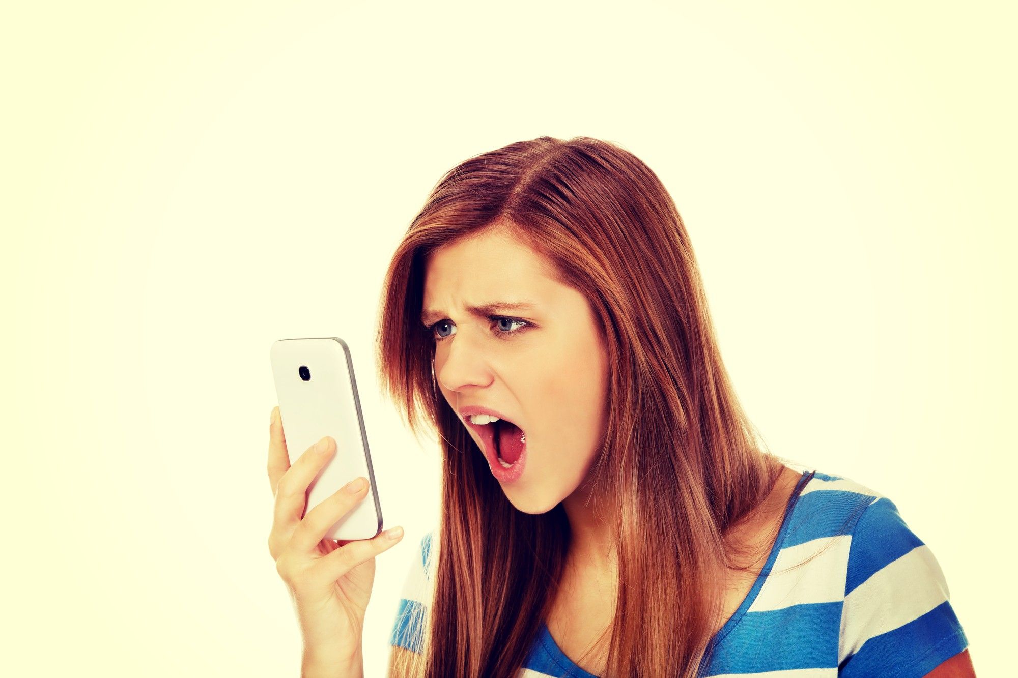 young woman staring at cell phone, shocked