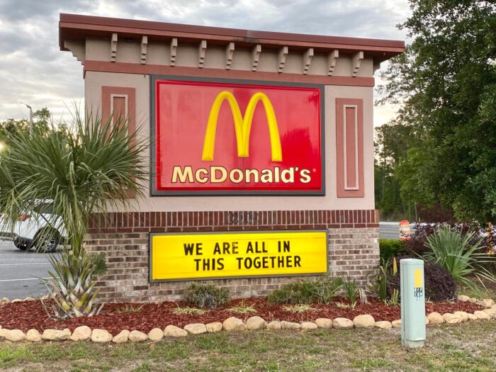 McDonald’s store road sign reads"We are all in this together" to encourage people during this world wide coronavirus COVID-19 pandemic.