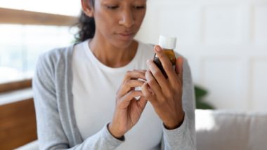 Woman reads pill bottle label