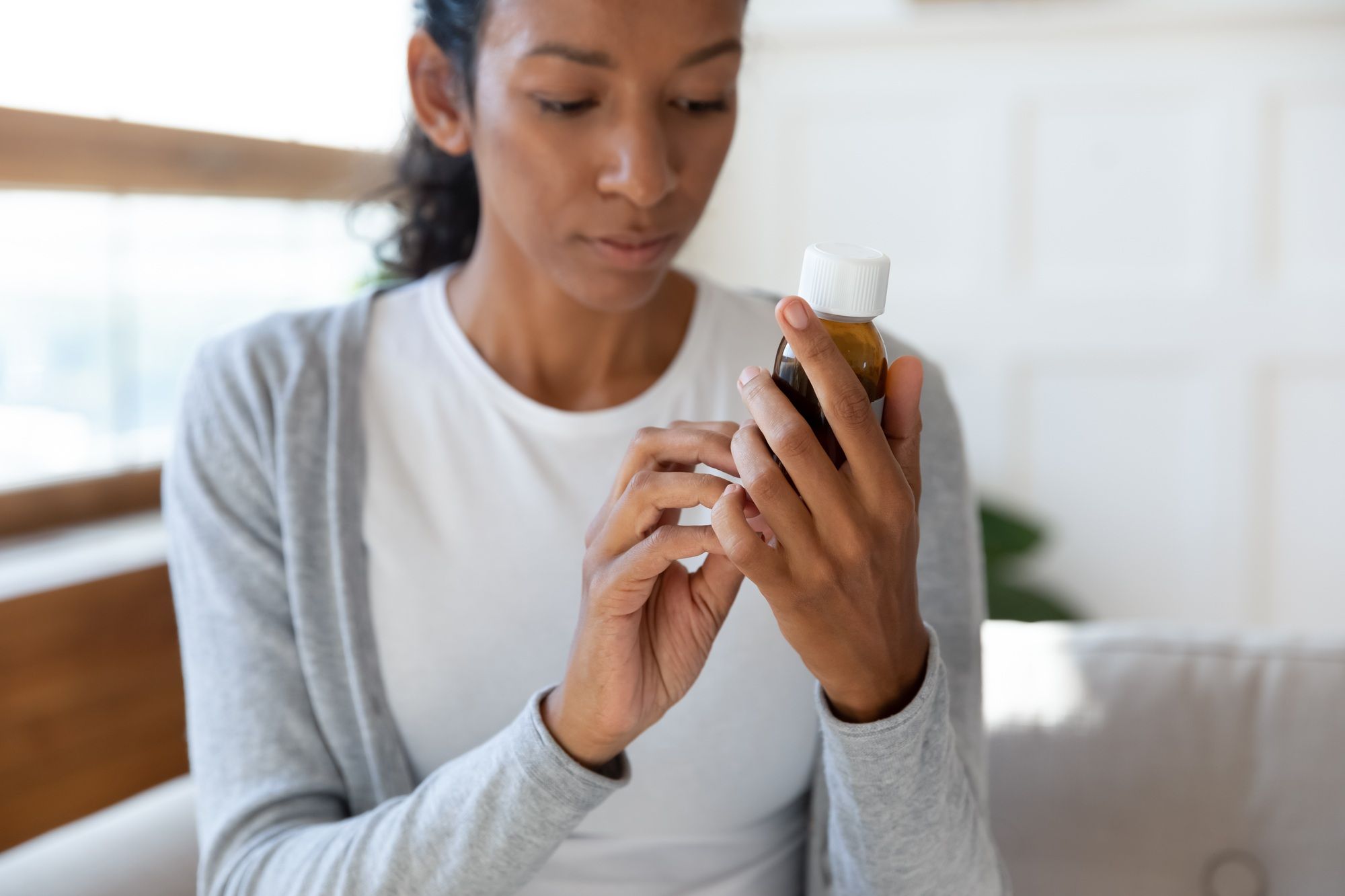 Woman reads pill bottle label