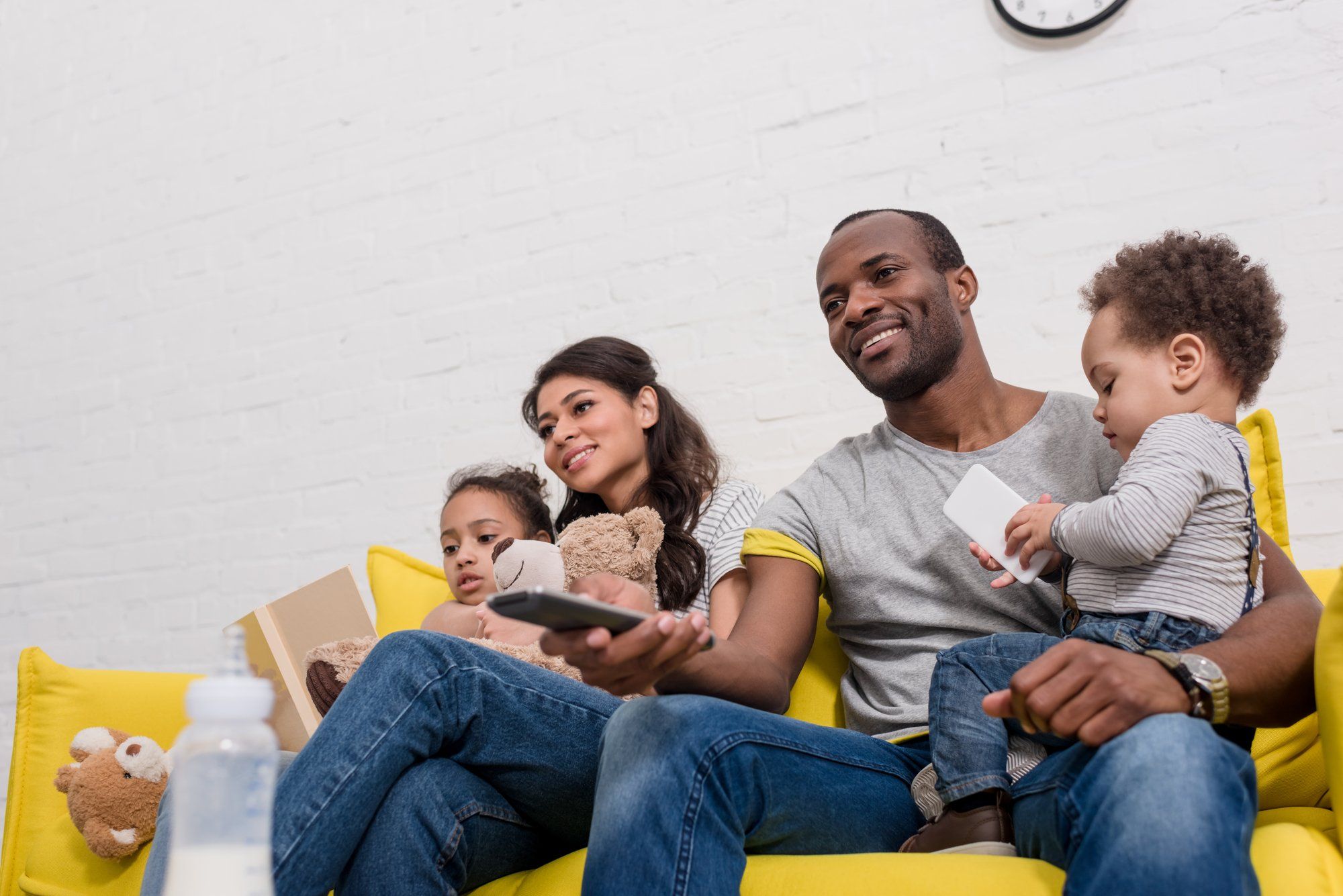 Young family watches TV from couch