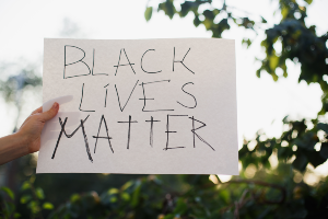 Hand holding sign that says "Black Lives Matter"