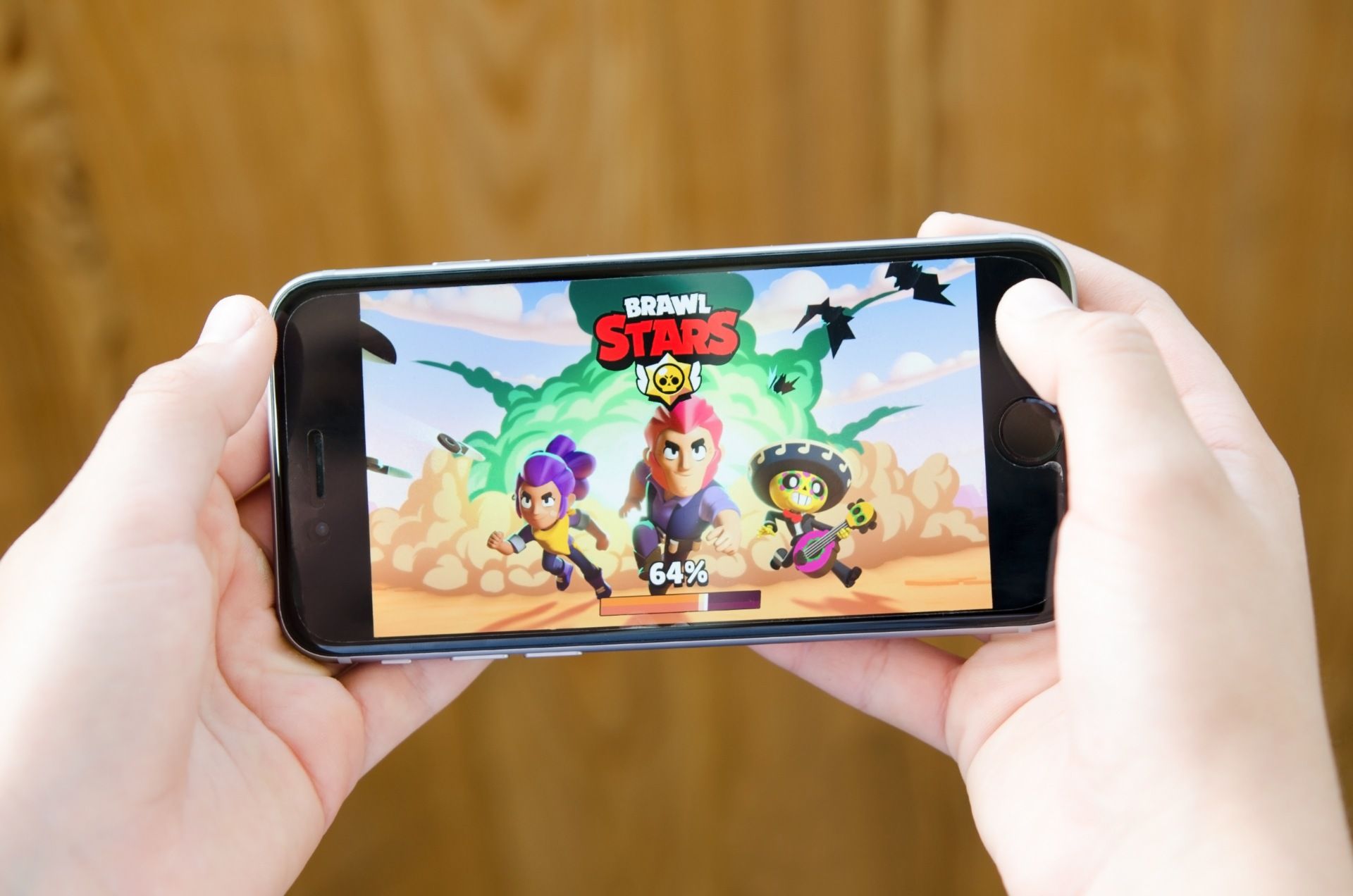 Child holding an iphone displaying the load screen for the game Brawl Stars