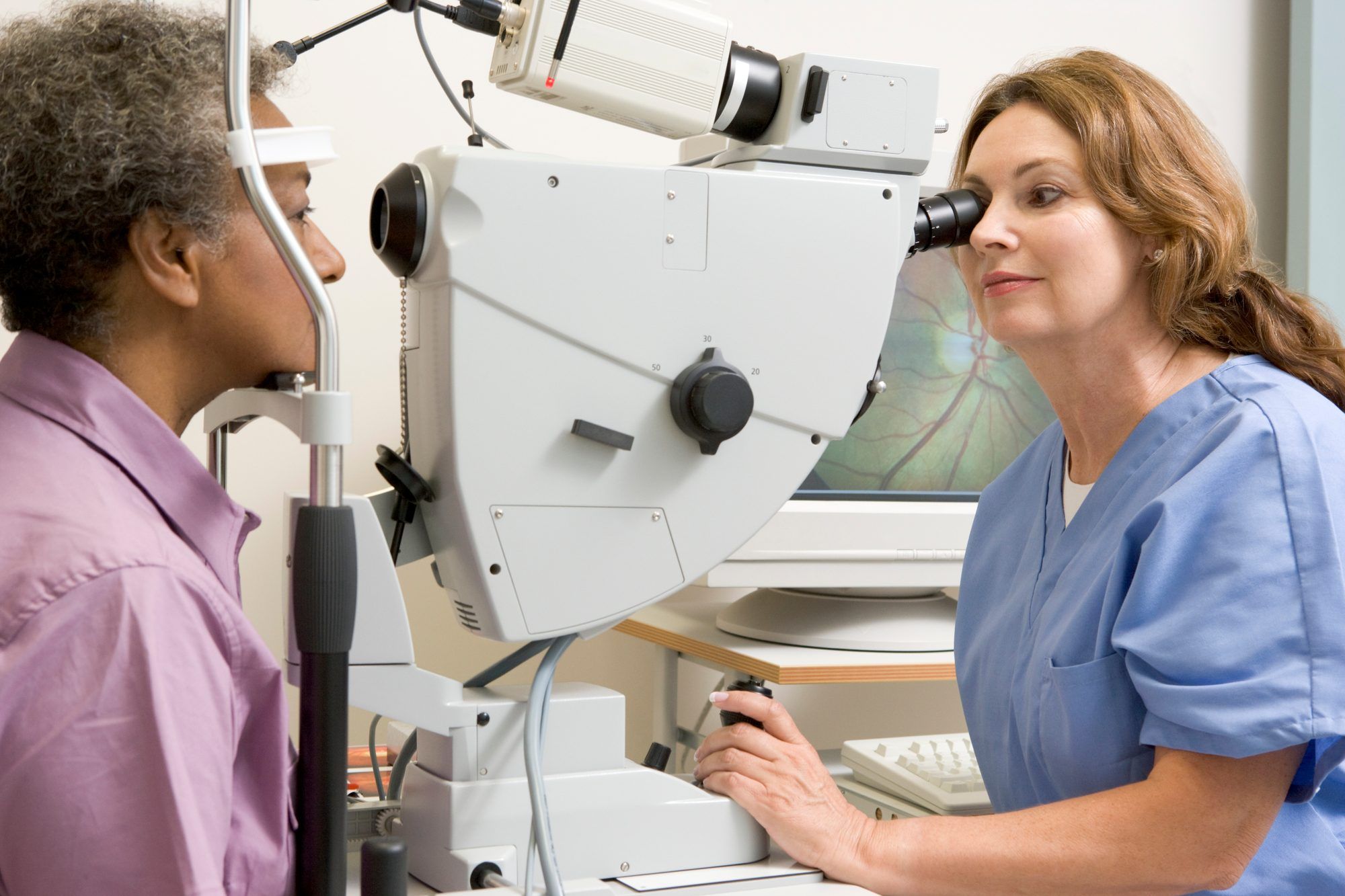 Female doctor provides eye exam to female patient