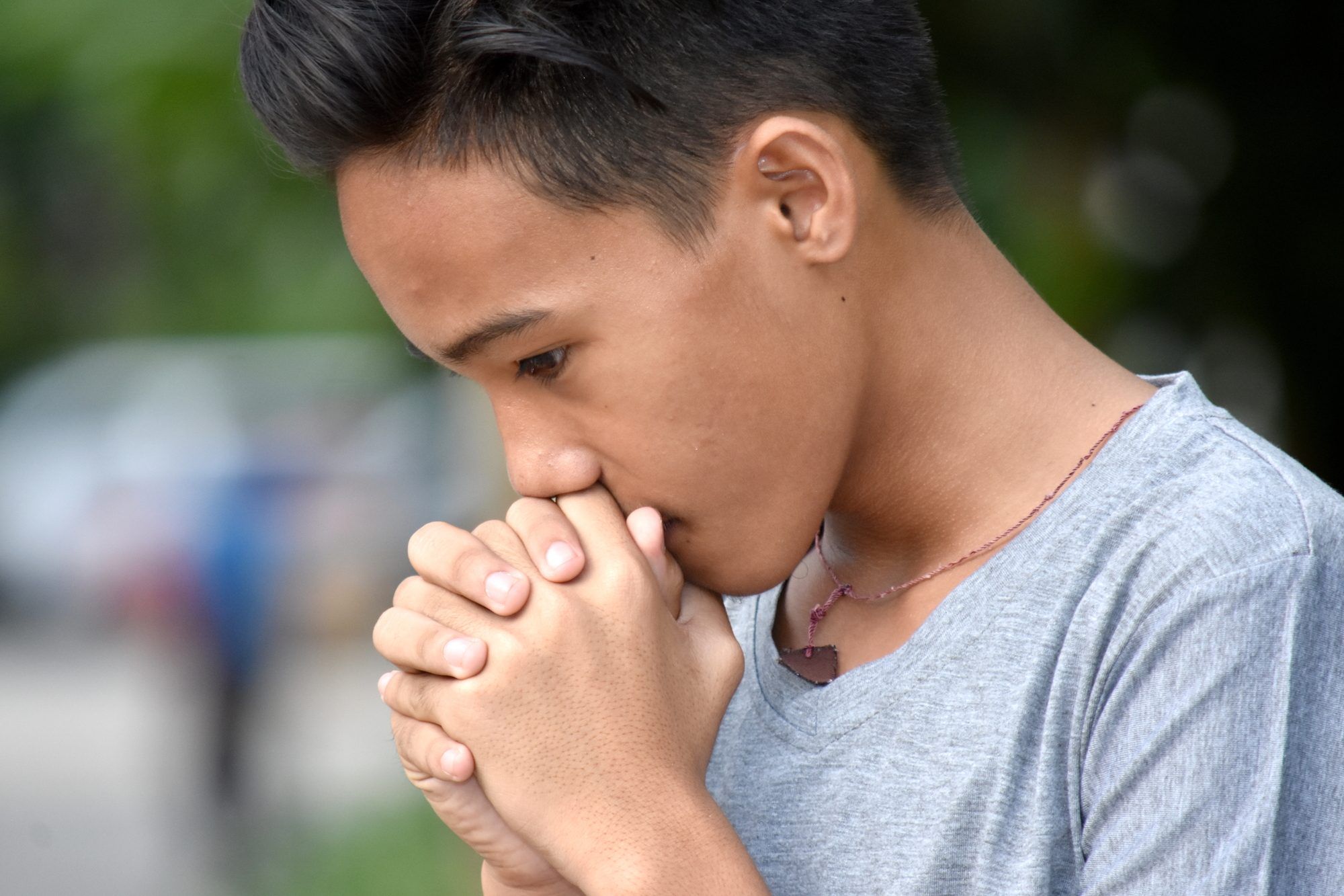 Praying teen boy with serious expression
