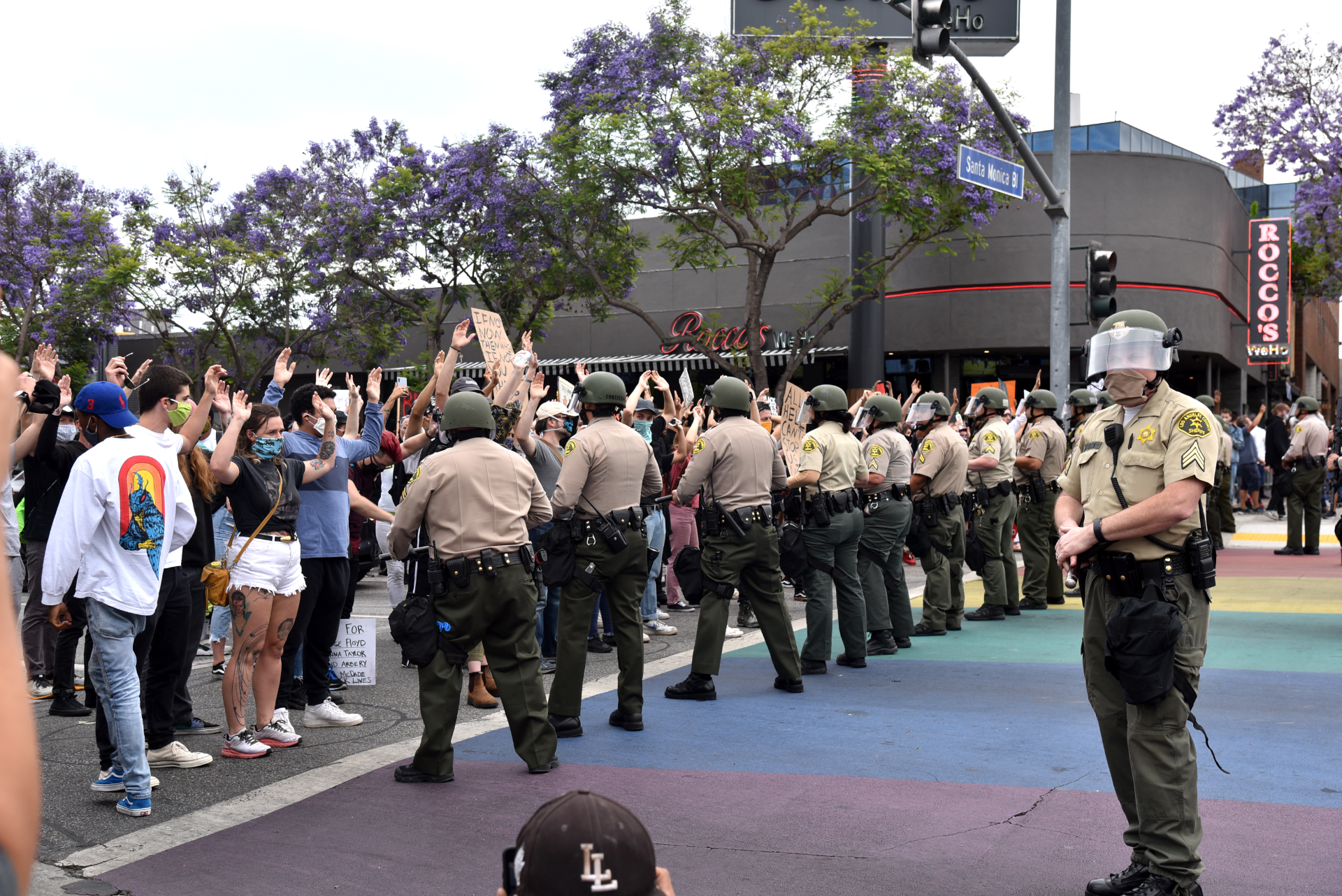 A line of police in West Hollywood hold back a protesting crowd