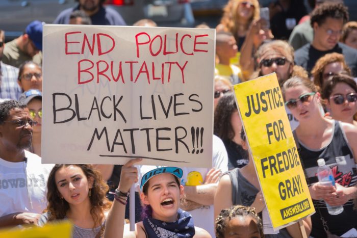 peaceful protesters holding signs to end police brutality