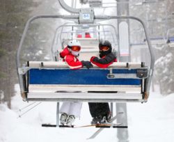 skiers on ski-lift heading up to a ski resort