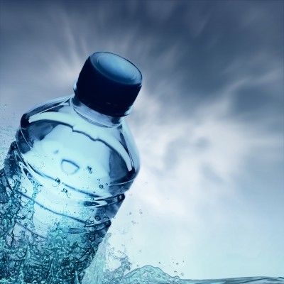 Botted water with blue cap on grey background