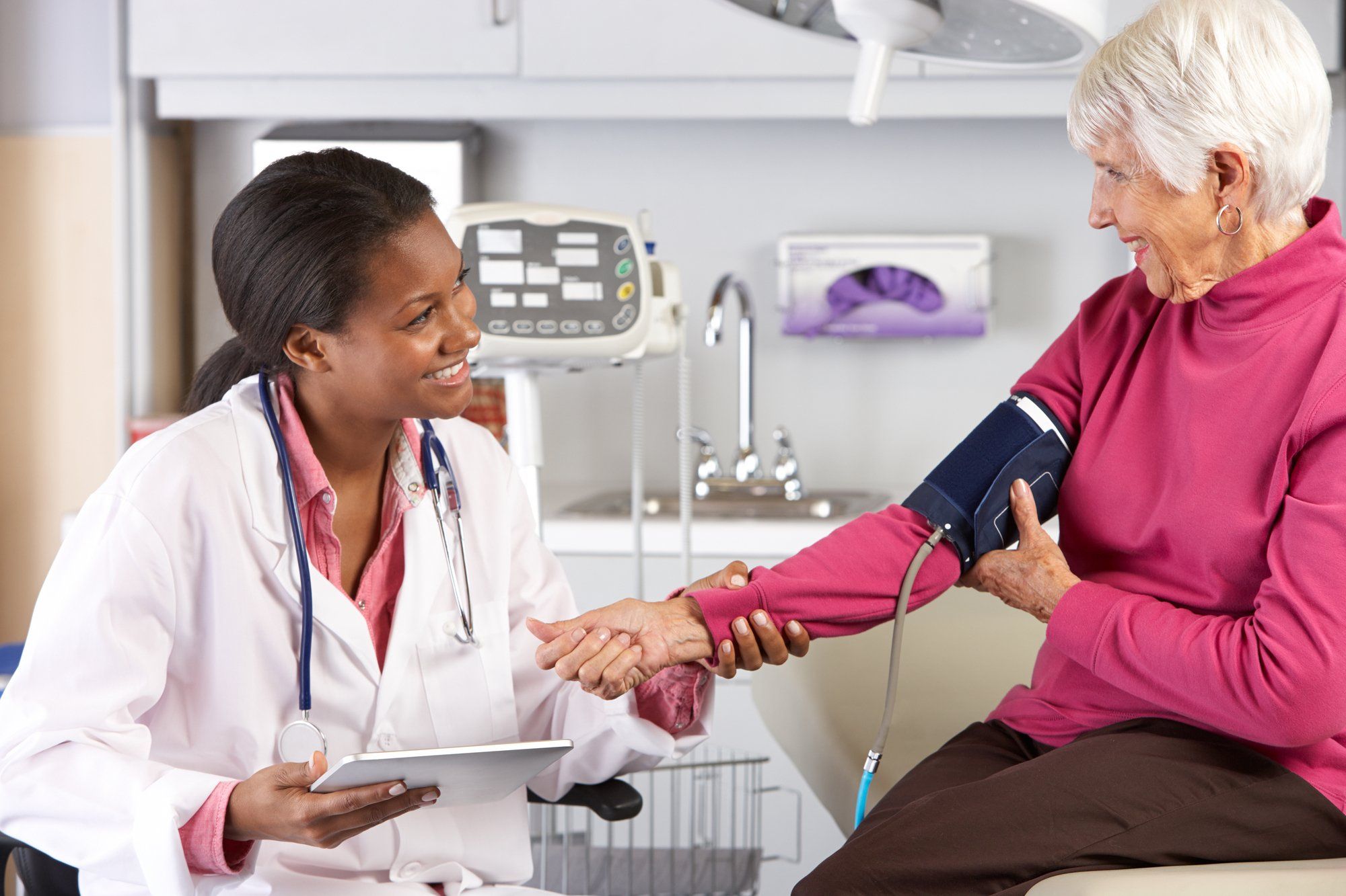 Female doctor takes blood pressure of elderly woman
