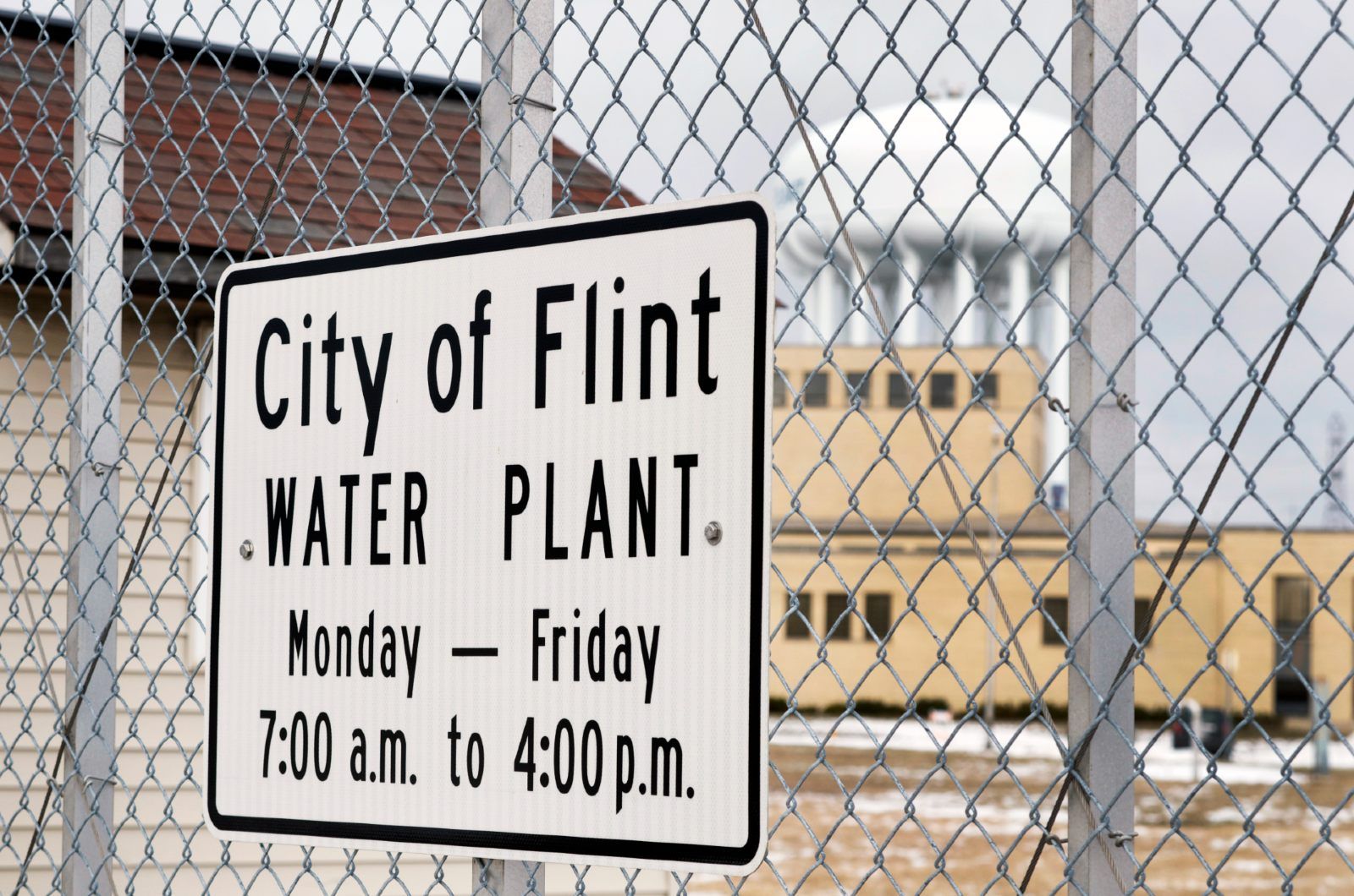 Sign on fence in front of Flint, Mich., water plant - Flint water