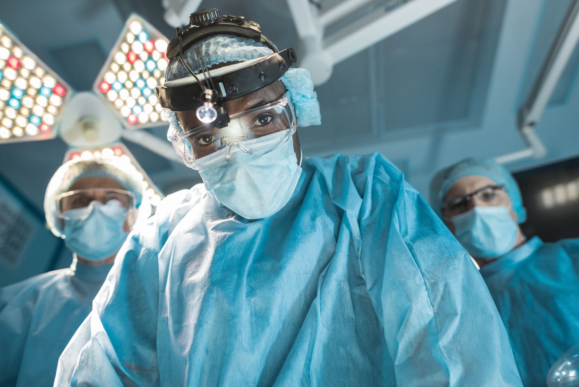 Surgeon leans over patient in operating room