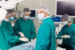 Four doctors operate on patient in operating room
