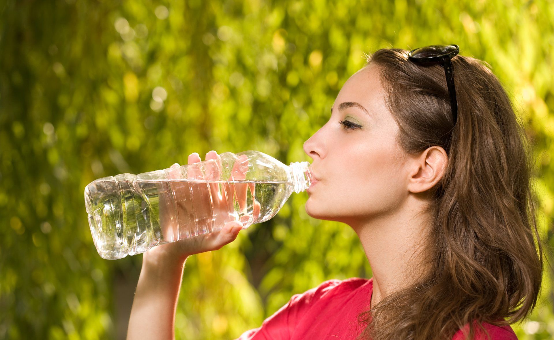 Woman outside drinking bottle of water