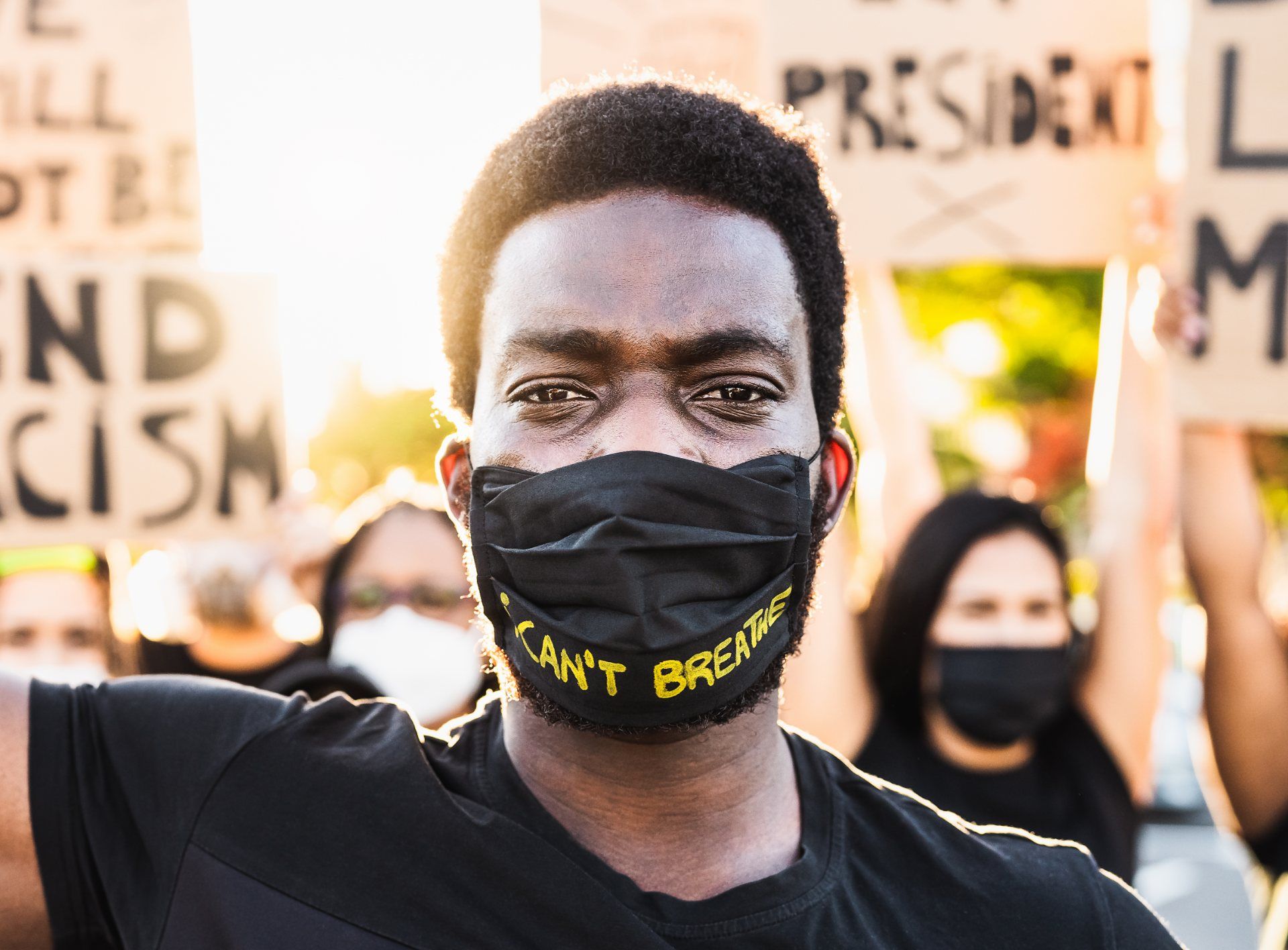 Black man wearing "I can't breathe" face mask stands in front of other protesters - portland protests