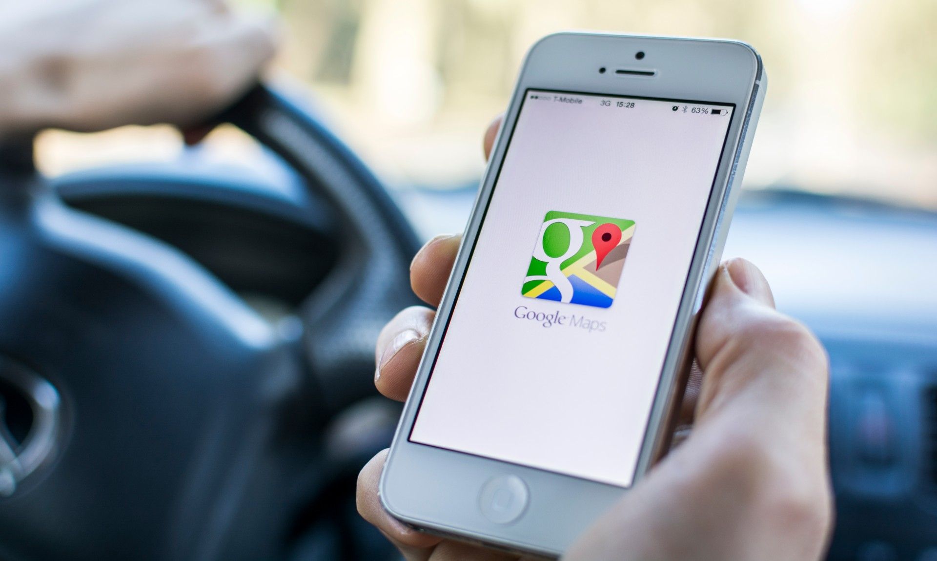 Driver holds iPhone showing Google Maps app screen